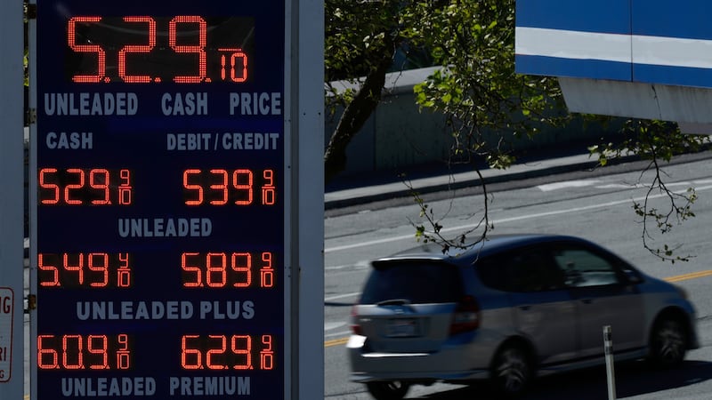 Un automóvil circula detrás del cartel de precios de gasolina de una gasolinera en San...