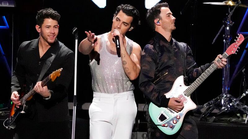 Nick (izq.), Joe (centro) y Kevin Jonas de la banda Jonas Brothers durante un concierto en...