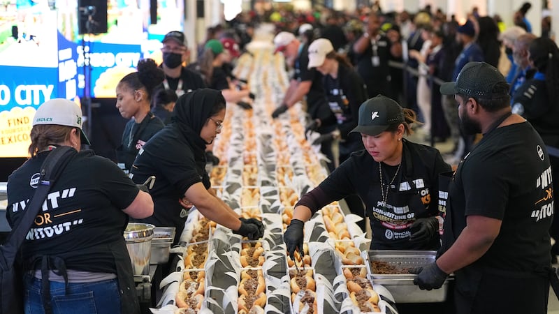 Un grupo de voluntarios preparan cheesesteaks en un intento de lograr un récord Guinness en el...
