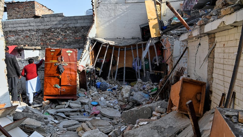 Funcionarios revisan los daños en una casa causada por la explosión de una bombona, horas...