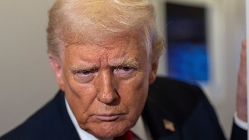 El presidente de Estados Unidos, Donald Trump, se inclina hacia delante para escuchar una...