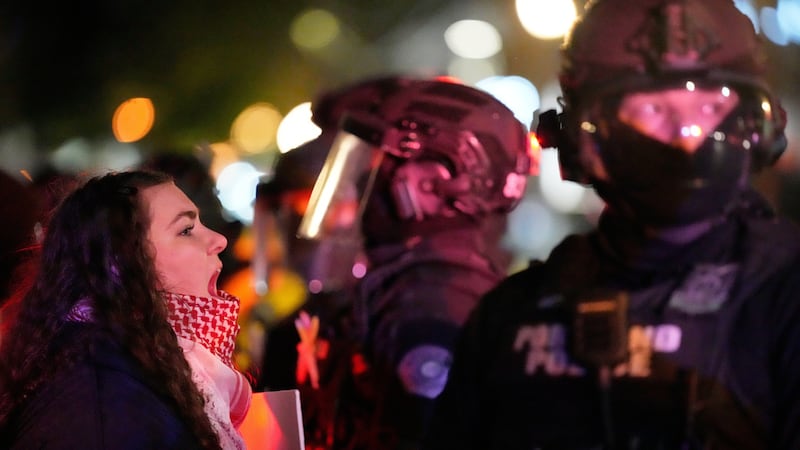 Una manifestante grita a un agente de la policía de Portland en el exterior de un edificio de...