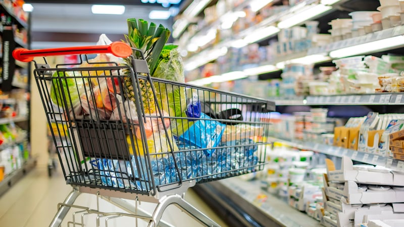 A shopping cart with grocery products in a supermarket