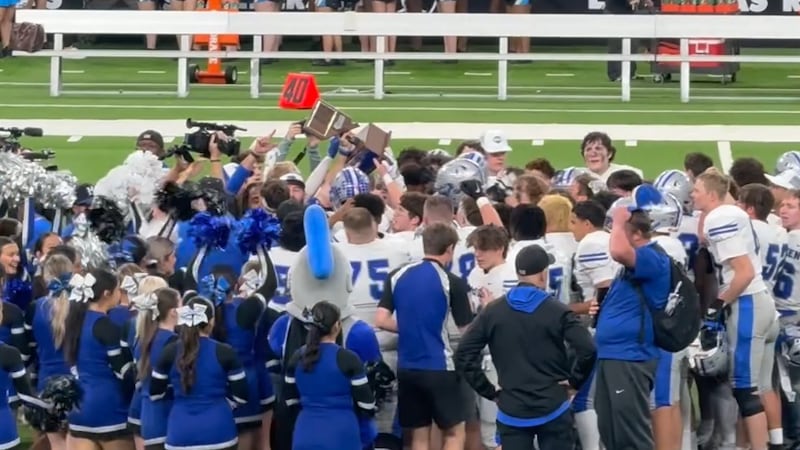 El equipo de fútbol americano de McQueen High School celebra tras ganar el campeonato estatal...