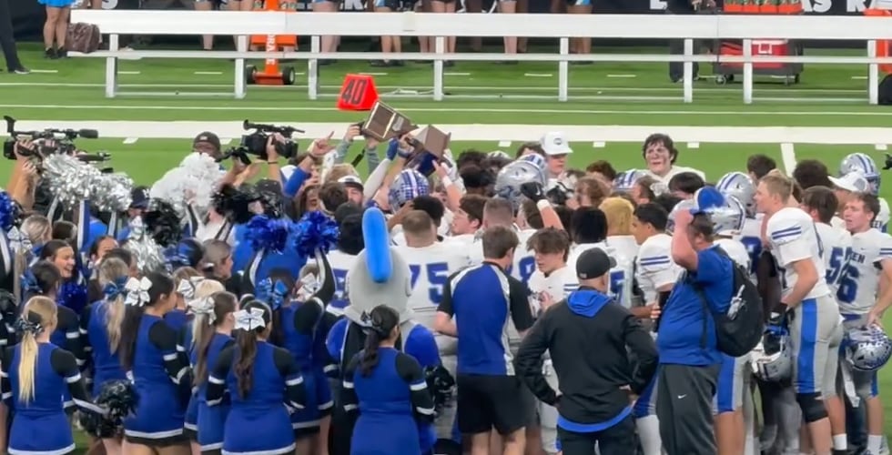 El equipo de fútbol americano de McQueen High School celebra tras ganar el campeonato estatal...