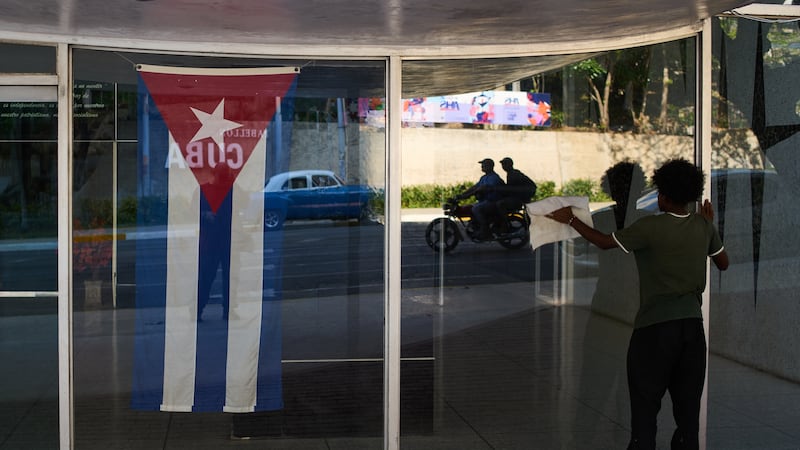 Un trabajador limpia las ventanas del Ministerio de Salud en La Habana, Cuba, el viernes 20 de...