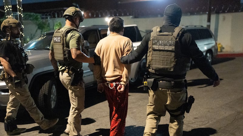 Policías escoltan a una persona acusada de votar ilegalmente en Commerce, California, el 19 de...